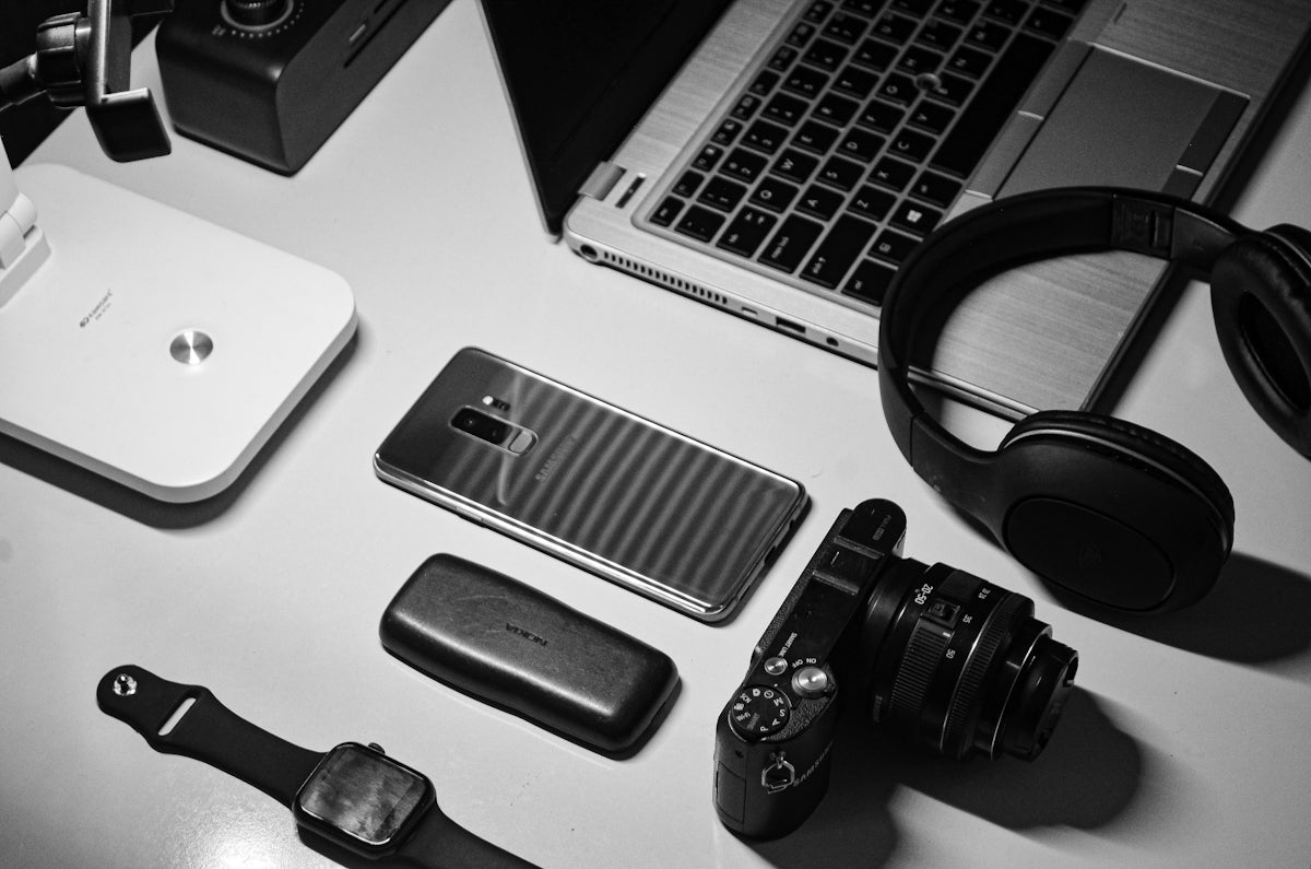 a white desk topped with electronics and a laptop