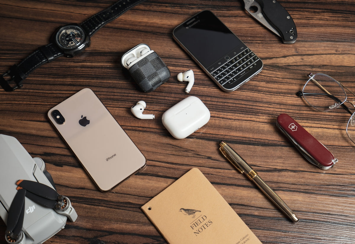 a wooden table topped with different types of electronics