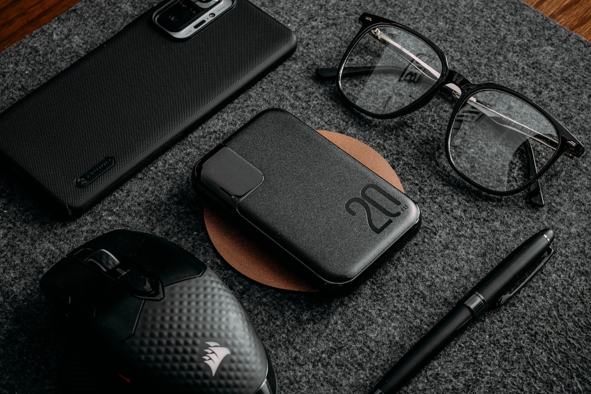 a black computer mouse and a pen on a black surface