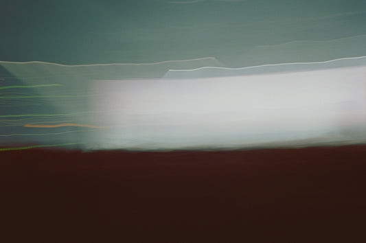 a blurry photo of a field with a sky in the background