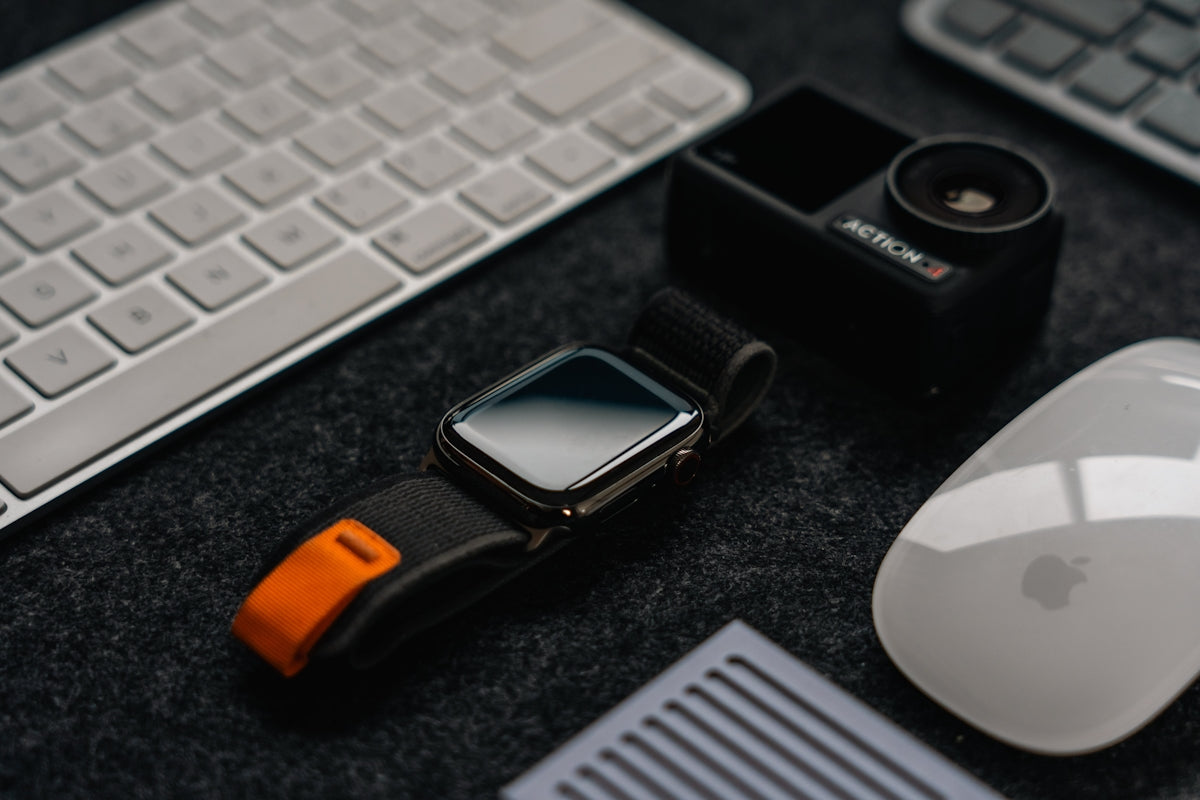 a cell phone, mouse, and keyboard on a desk